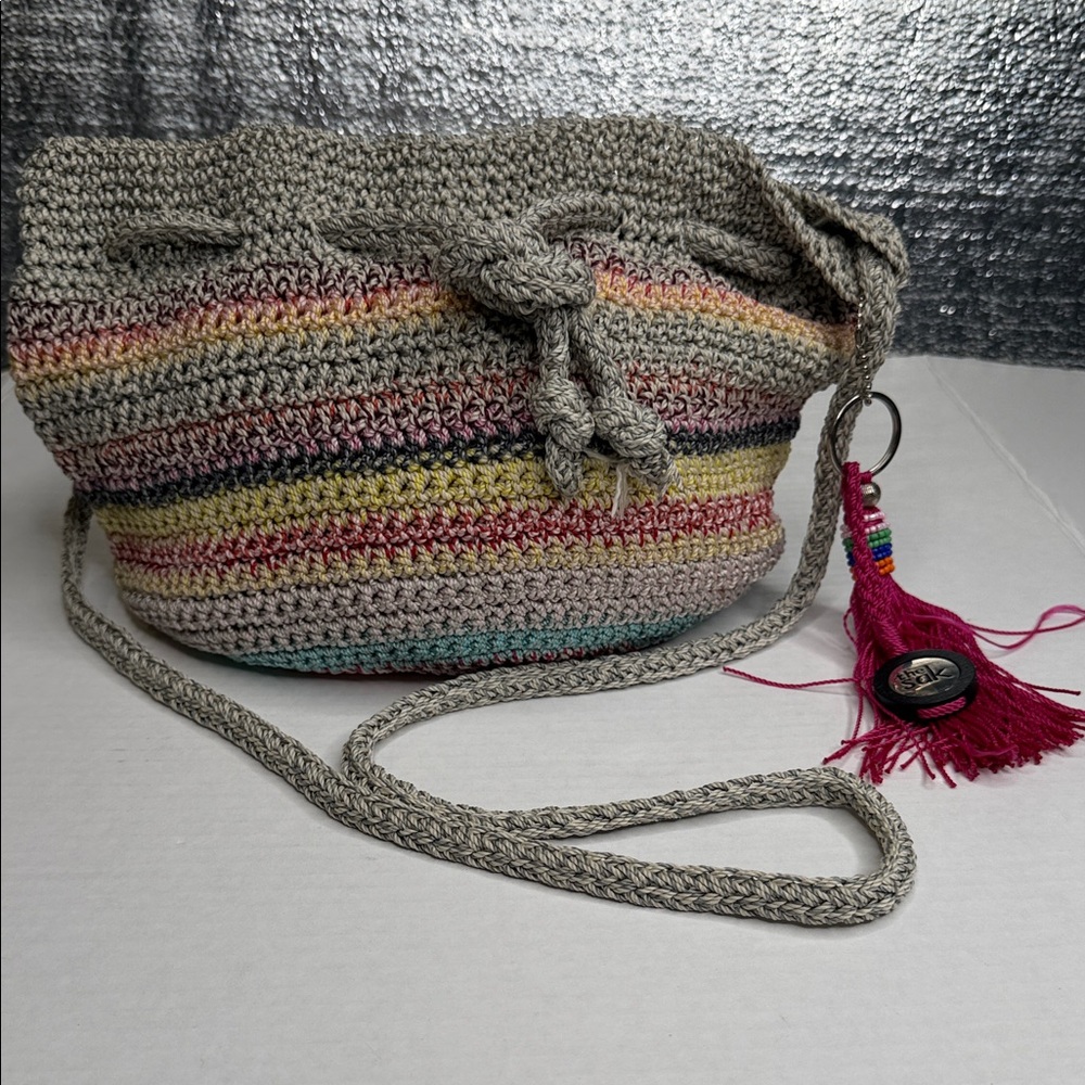 The Sak Crocheted Crossbody Bag in Gray with Multicolor Stripes and Pink Tassel